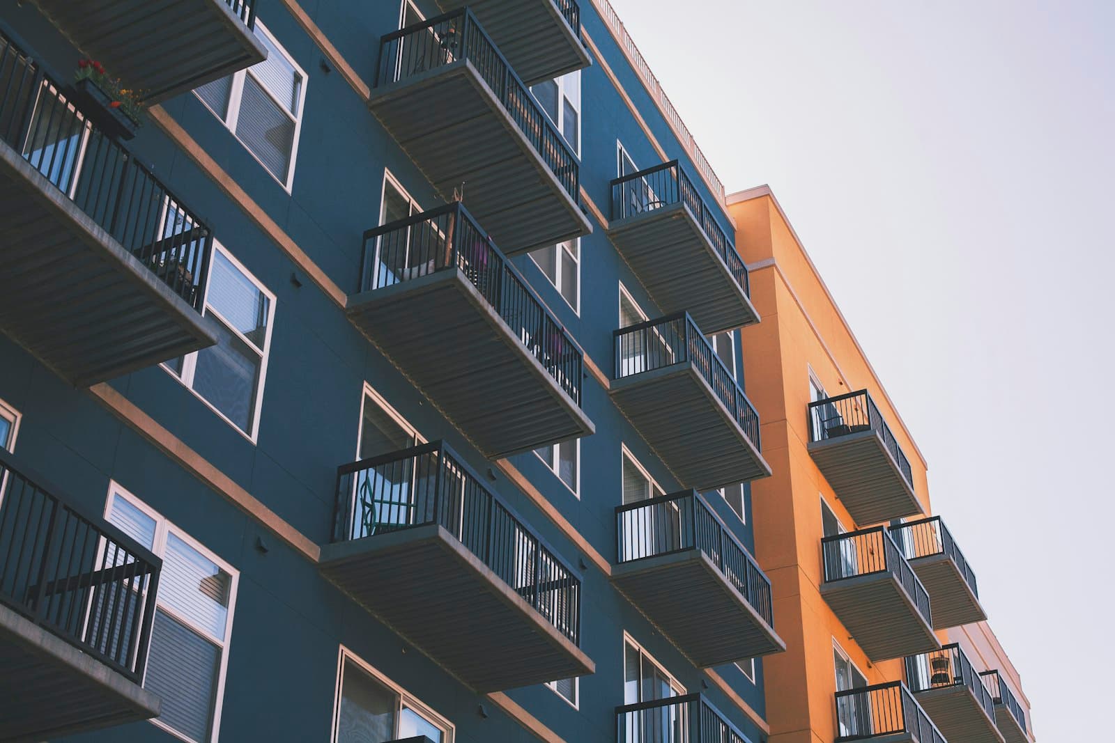 Blue and orange apartment building with rows of balconies
